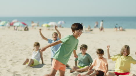 Tracking-shot-of-happy-Asian-boy-kicking-ball-with-head-on-beach